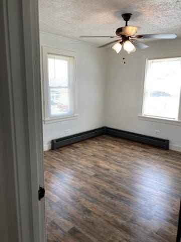 unfurnished room featuring ceiling fan, a textured ceiling, dark hardwood / wood-style flooring, and baseboard heating