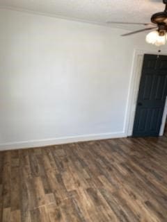 spare room featuring ornamental molding, dark wood-type flooring, and ceiling fan