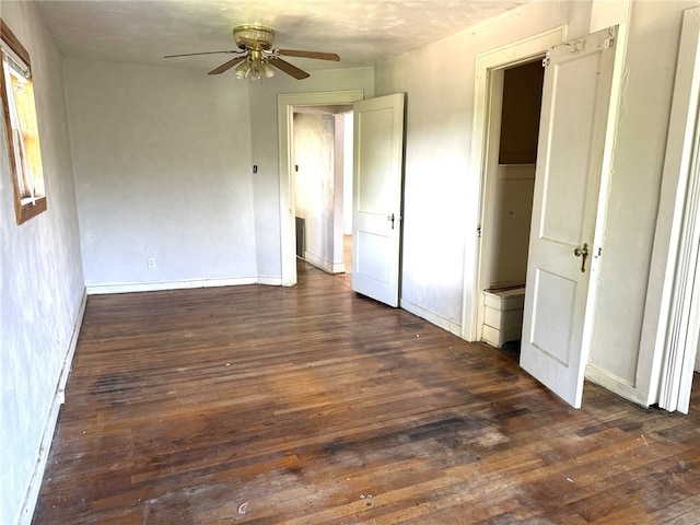 unfurnished bedroom featuring dark wood-type flooring and ceiling fan