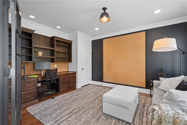 office area with dark hardwood / wood-style floors, built in desk, and crown molding