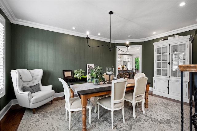 dining area featuring wood-type flooring and ornamental molding