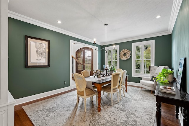 dining area featuring a notable chandelier, dark hardwood / wood-style floors, crown molding, and a wealth of natural light