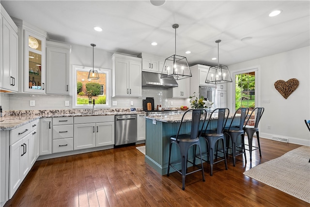 kitchen with pendant lighting, white cabinetry, a center island, and dishwasher