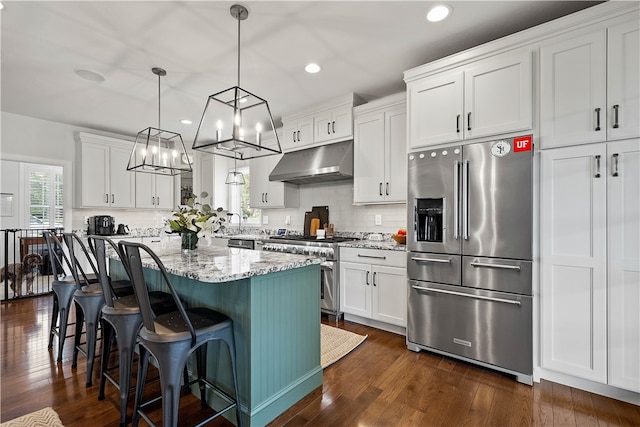 kitchen featuring decorative light fixtures, high end appliances, dark hardwood / wood-style floors, and white cabinets