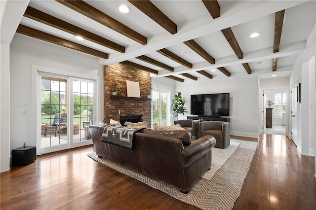 living room featuring a wealth of natural light, beam ceiling, dark hardwood / wood-style floors, and a fireplace