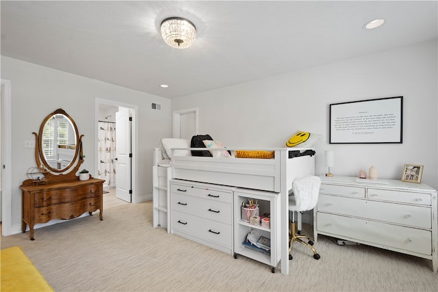 bedroom featuring ensuite bath and light colored carpet