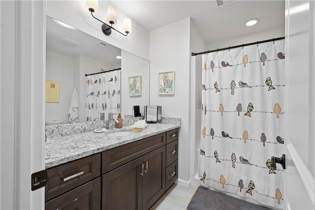 bathroom featuring walk in shower, vanity, and toilet