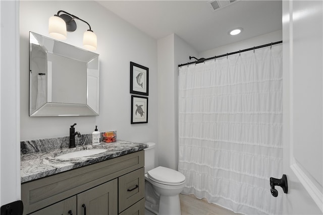 bathroom featuring curtained shower, wood-type flooring, vanity, and toilet