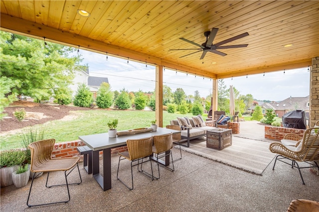 view of patio / terrace with ceiling fan and an outdoor living space with a fire pit