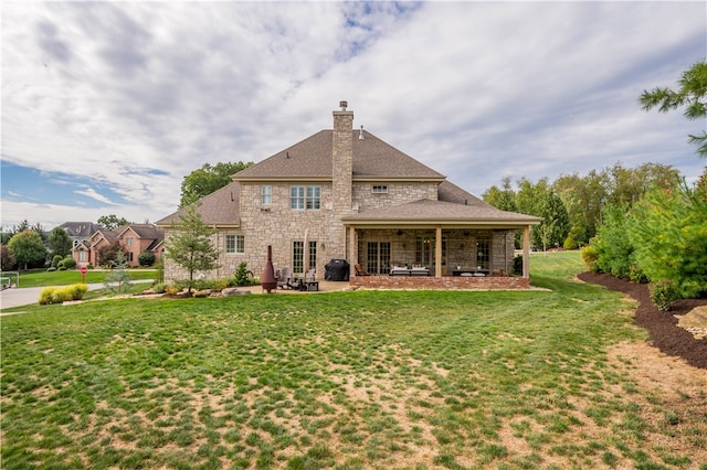 rear view of house featuring a patio and a yard