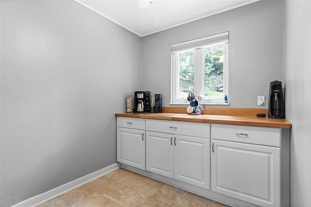 kitchen featuring butcher block countertops and white cabinets