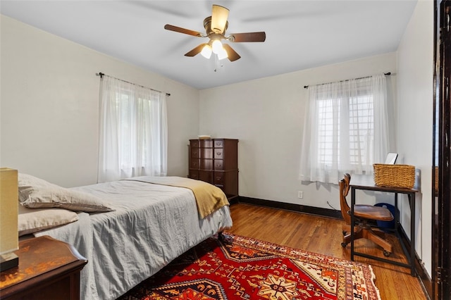 bedroom with multiple windows, ceiling fan, and light hardwood / wood-style flooring