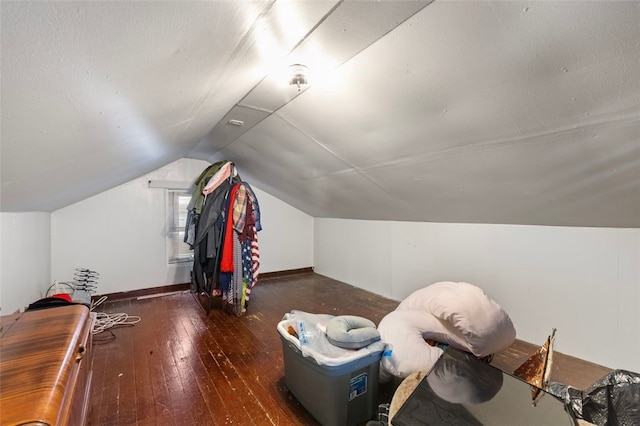 bonus room with vaulted ceiling and dark wood-type flooring