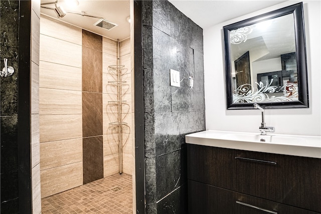 bathroom with tile walls, tiled shower, and vanity