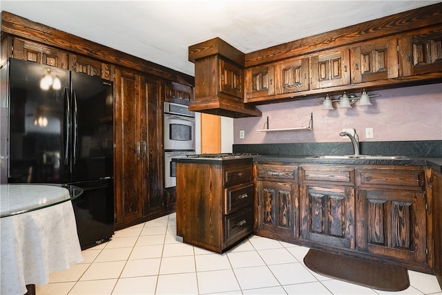 kitchen featuring sink, light tile patterned floors, dark brown cabinets, double oven, and black refrigerator