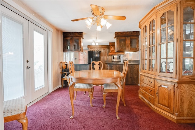 dining space with dark carpet, ceiling fan, and french doors