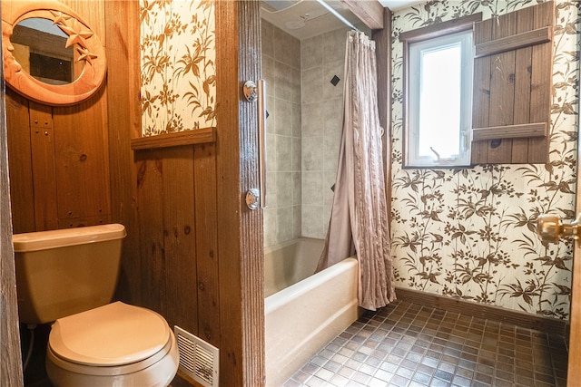 bathroom featuring tile patterned floors, shower / tub combo, and toilet