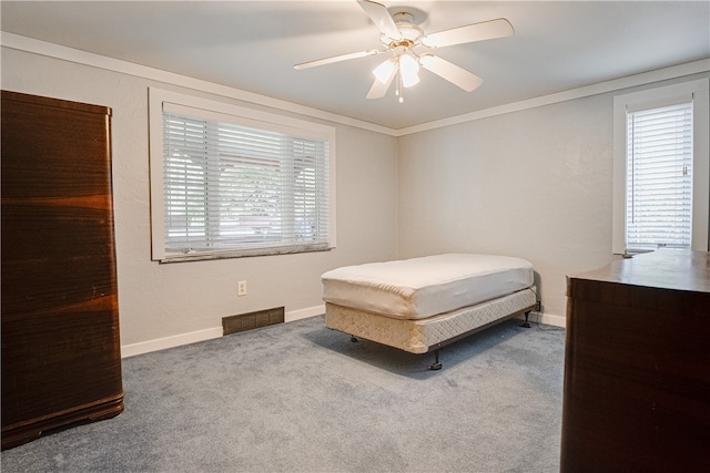 carpeted bedroom with ornamental molding and ceiling fan