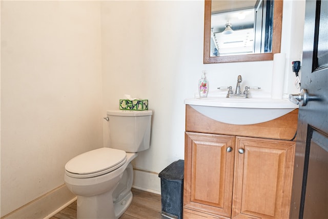 bathroom featuring vanity, toilet, and hardwood / wood-style flooring