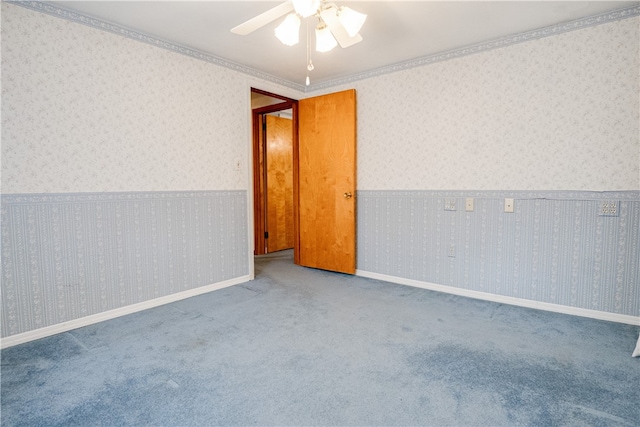 spare room with ceiling fan, crown molding, and carpet