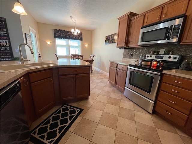 kitchen with sink, decorative light fixtures, backsplash, a chandelier, and appliances with stainless steel finishes