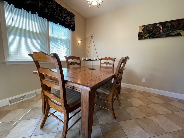 tiled dining space featuring an inviting chandelier