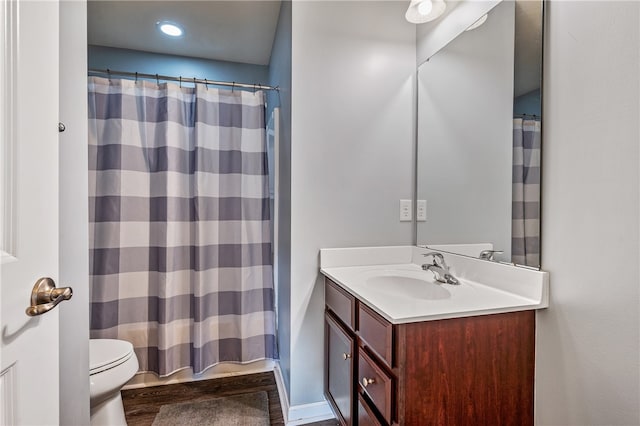 bathroom featuring curtained shower, hardwood / wood-style floors, vanity, and toilet