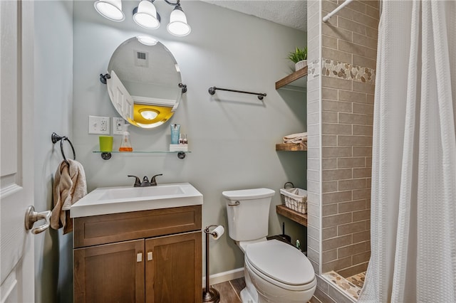 bathroom featuring vanity, a textured ceiling, hardwood / wood-style flooring, walk in shower, and toilet