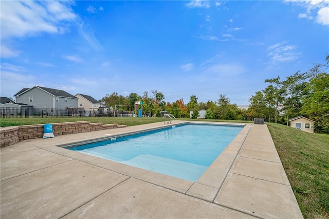 view of swimming pool with an outbuilding and a yard