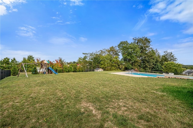 view of yard featuring a playground and a fenced in pool