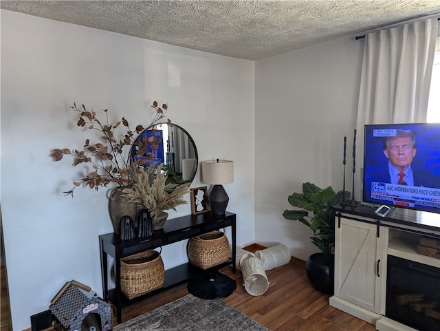 interior space featuring a textured ceiling, a fireplace, and dark hardwood / wood-style floors