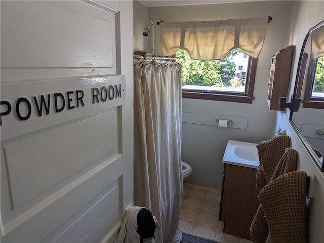 bathroom with a wealth of natural light, vanity, and toilet