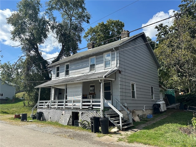 view of front of home featuring covered porch and a front yard