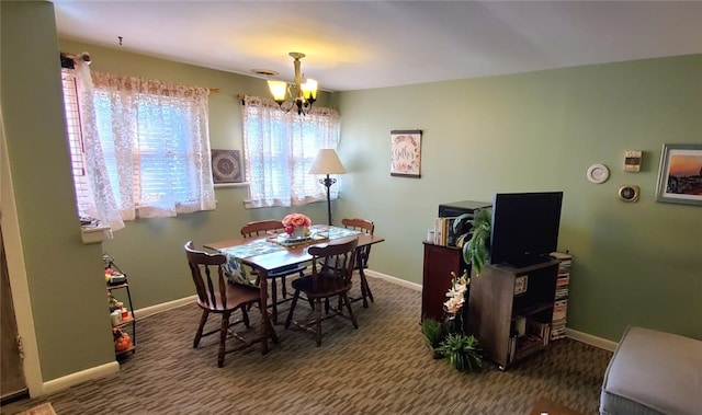 dining room featuring dark carpet and a chandelier