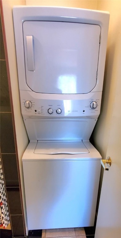 washroom featuring light tile patterned flooring and stacked washer and dryer