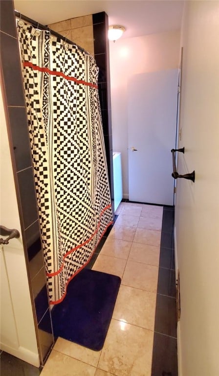 bathroom featuring walk in shower and tile patterned flooring