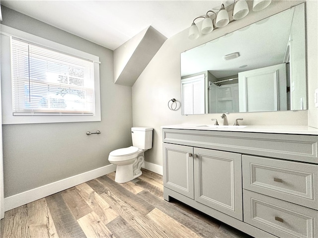 bathroom with vanity, toilet, walk in shower, and hardwood / wood-style floors