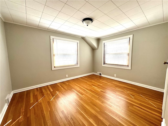 unfurnished room with crown molding and hardwood / wood-style flooring