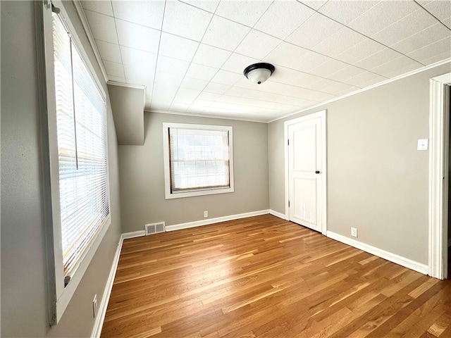 spare room featuring light hardwood / wood-style flooring and ornamental molding