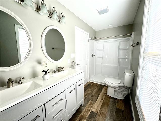 bathroom featuring vanity, toilet, a shower, and hardwood / wood-style floors