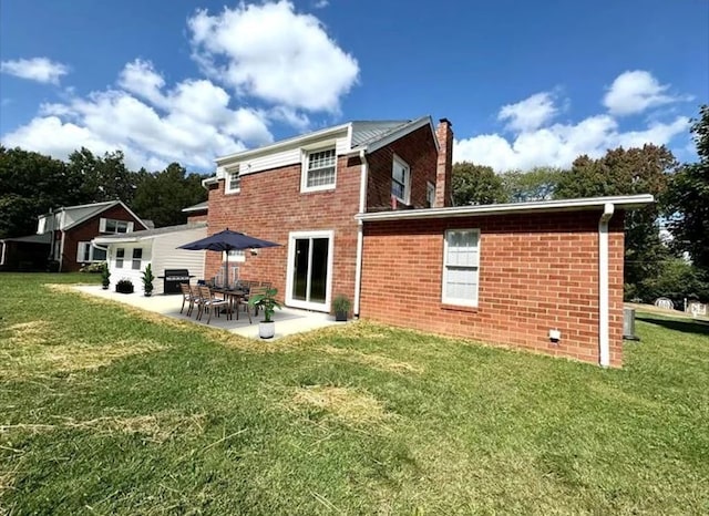 rear view of property with a yard and a patio