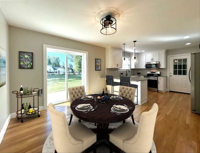 dining space featuring light hardwood / wood-style floors and sink