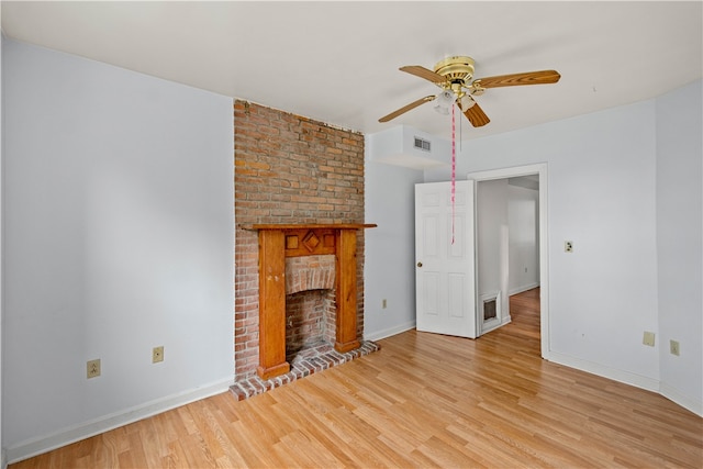 unfurnished living room with light hardwood / wood-style floors, ceiling fan, and a brick fireplace