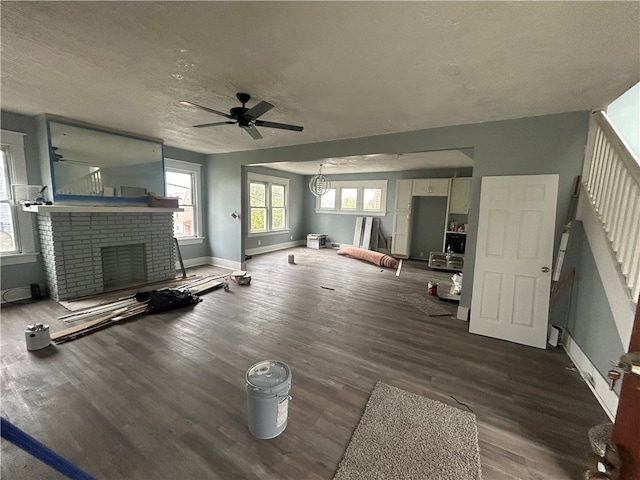 unfurnished living room with a textured ceiling, wood-type flooring, a fireplace, and ceiling fan