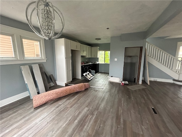 living room with a textured ceiling, wood-type flooring, and a notable chandelier