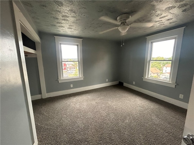 empty room with a textured ceiling, carpet, and ceiling fan