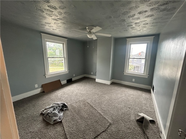 spare room with a textured ceiling, ceiling fan, and carpet floors