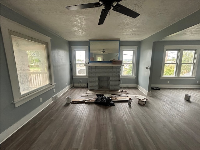 unfurnished living room featuring a brick fireplace, ceiling fan, and a healthy amount of sunlight