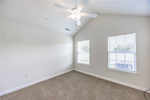 carpeted spare room with a healthy amount of sunlight, vaulted ceiling, and ceiling fan