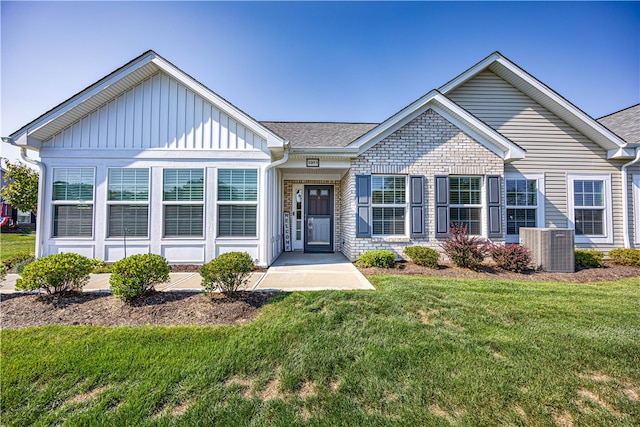 view of front of home featuring a front lawn and central AC unit